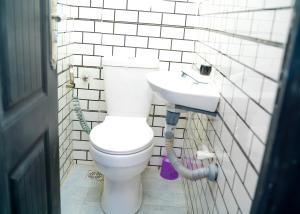 a bathroom with a white toilet and a sink at Riverside Nest Owerri Ltd in Owerri