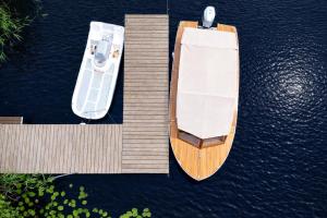 an overhead view of a boat on a dock at 4jeziora - prywatny dostęp do rzeki, pomost, ogrodem, wiata grillowa, rowerek wodny, kajaki w cenie, parking, psiaki dozwolone in Iława