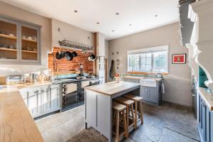 a large kitchen with a counter and a brick wall at Bressingham Lodge by Leap Escapes in Diss