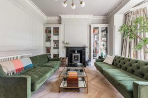 a living room with a green couch and a fireplace at Bressingham Lodge by Leap Escapes in Diss