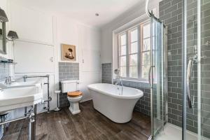 a bathroom with a tub and a sink and a toilet at Bressingham Lodge by Leap Escapes in Diss +53 photos