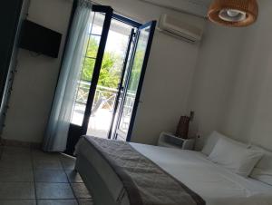 a bedroom with a bed and a large window at arome de grenade in Nea Epidavros