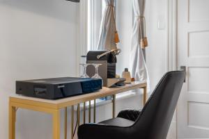 a desk with a computer and a chair at Hotel Charles-Alexandre - Par Aneyro in Quebec City