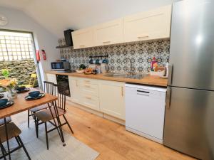 a kitchen with a stainless steel refrigerator and a table at Burford Apple in Burford