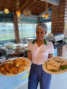 a young girl holding a plate of food at Pousada Vasto Horizonte in Barreirinhas