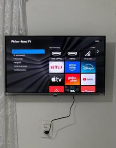 a flat screen tv hanging on a wall at Casa Recanto- Vila Uryah in Caraíva