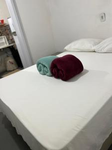 a white bed with two pillows on it at Casa Recanto- Vila Uryah in Caraíva
