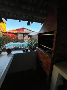 a backyard with a swimming pool and a brick wall at Casa Recanto- Vila Uryah in Caraíva +2 photos