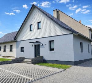a white house with a driveway in front of it at Ferienwohnung Storchennest in Eisfeld