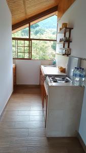 a kitchen with a stove and a large window at Mindo Suites - Toucans in Quito