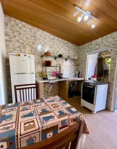 a kitchen with a table and a refrigerator at Casa do Aconchego - Quitinete I in Governador Celso Ramos +6 photos