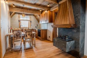 a kitchen and dining room with a table and a stove at Domki Góralska Przystań in Białka Tatrzańska