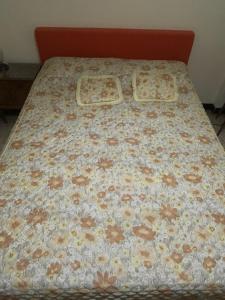 a bed with a flowered bedspread on it at Monoambiente a 100 m del mar in Necochea
