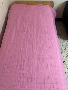 a pink comforter on a bed in a room at Monoambiente a 100 m del mar in Necochea