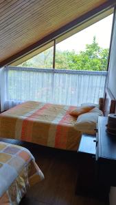 two beds in a room with a large window at Mindo Suites - Toucans in Quito