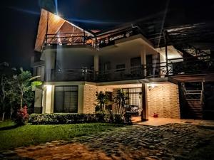a house at night with the lights on at Mindo Suites - Toucans in Quito