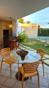 a patio with a glass table and chairs and a table and chairs at Pitaia 3 in Aracaju