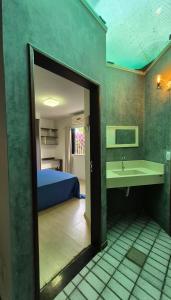 a room with a bathroom with a sink and a bed at Pitaia 3 in Aracaju