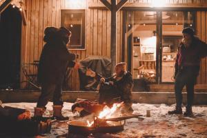 a group of people standing around a fire at Huttopia Berkshires in Hancock +44 photos