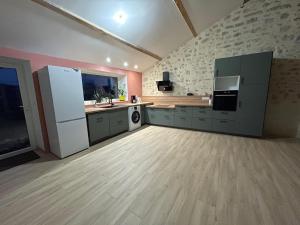 a large kitchen with a refrigerator and a sink at La Mar'Hel in Taxat-Senat