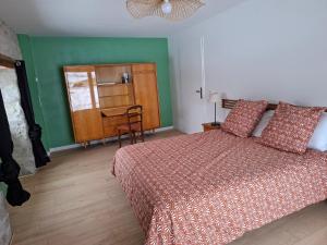 a bedroom with a bed and a table and a chair at La Mar'Hel in Taxat-Senat