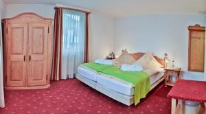sypialnia z łóżkiem z zielonym kocem w obiekcie Hotel Zur Eisenbahn w mieście Renningen