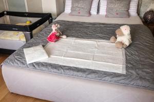 two stuffed teddy bears sitting on a bed at Wohnung mit Charme, Netflix in Rheinstetten +14 photos
