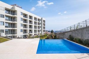 an empty swimming pool in front of a building at Oceanfront Bliss - Atlantico residences in Câmara de Lobos