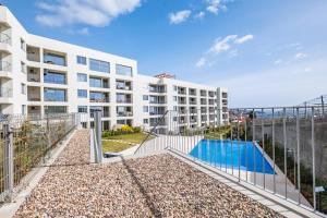 an apartment building with a swimming pool in front of it at Oceanfront Bliss - Atlantico residences in Câmara de Lobos