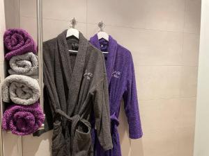 a purple robe hanging on a rack in a bathroom at Studio 3 étoiles avec grand JACUZZI PRIVÉ in Horbourg