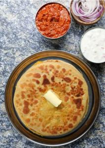 a plate of food with a piece of cheese on it at Hotel Venus in Jabalpur
