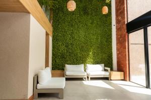a lobby with two chairs and a green wall at Sereno Hotel in Cabo Frio