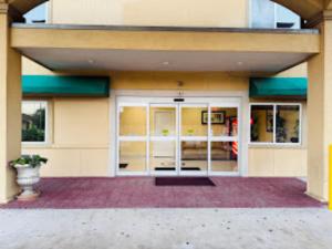 a building with a front door with a porch at Budget Host Inn Stafford - Houston in Houston +8 photos