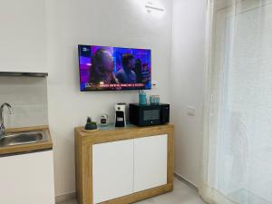 a flat screen tv on a wall above a counter at AZZURRO meraviglioso attico a pochi passi dal mare in Valledoria +61 photos