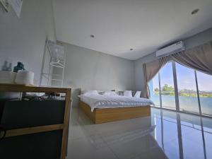 a bedroom with a bed and a large window at Safary Tour in Ban Ta Kun