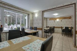 a dining room with tables and chairs and a window at Willa Świerkowa in Karpacz