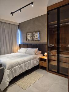 a bedroom with a large bed and a glass door at STÚDIO 017 - Novo e Sofisticado! in Sao Jose do Rio Preto +286 photos