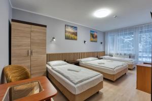 a hotel room with two beds and a table at Willa Świerkowa in Karpacz
