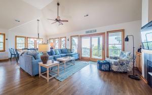 a living room with a blue couch and a table at Sunset Royale - Duck, Sanderling, Soundfront, Sound View, Beach 350 Yds, Community Pool, Kayak, YR Flex Stays in Duck