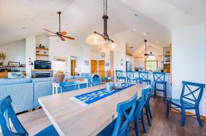 a dining room and living room with a table and chairs at Sunset Royale - Duck, Sanderling, Soundfront, Sound View, Beach 350 Yds, Community Pool, Kayak, YR Flex Stays in Duck