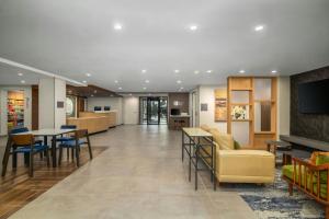 a lobby with a couch and a table and chairs at Fairfield by Marriott Inn & Suites Clinton in Clinton