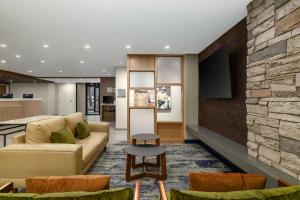 a living room with a couch and a stone wall at Fairfield by Marriott Inn & Suites Clinton in Clinton