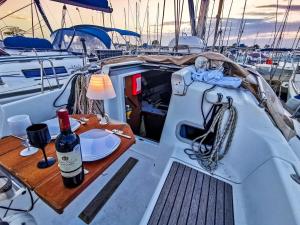 a table on the back of a boat with a bottle of wine at Voilier in Propriano
