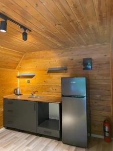 a kitchen with a stainless steel refrigerator and wooden walls at Yıldız Otel Dağ Evi in Çamlıhemşin +12 photos