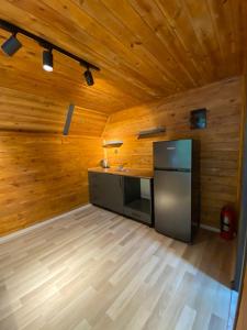 a kitchen with a stainless steel refrigerator and wooden walls at Yıldız Otel Dağ Evi in Çamlıhemşin