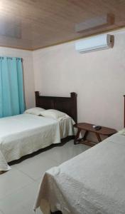 a hotel room with two beds and a table at Paradise Rio Celeste 2 in Bijagua
