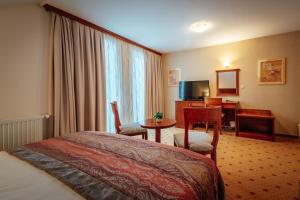 a hotel room with a bed and a desk at Kala B&B in Kranjska Gora