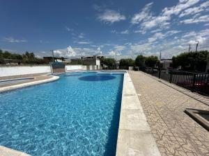 a swimming pool with blue water on a sidewalk at Casa Los Mangos 4 Piscinas 6 Camas y mucho Sol in Flandes