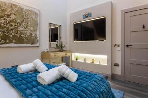 a bedroom with a blue bed with white pillows at Arran Shores Luxury Shorefront Penthouse Suite 13 in Lamlash