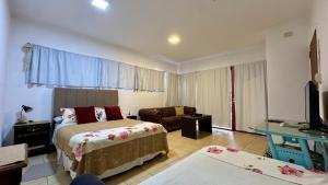 a hotel room with two beds and a couch at Plaza Departamentos Temporarios in Formosa